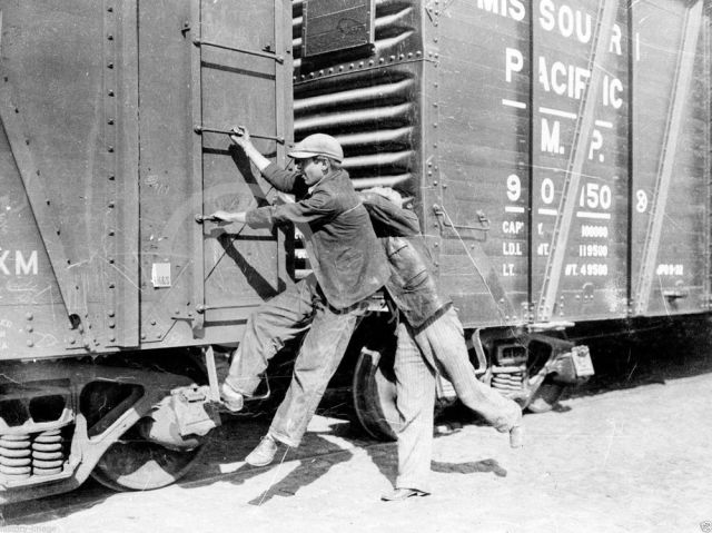 Teenagers hopping on a freight train during the Great Depression, ca. 1930s